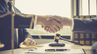 İş adamı, sözleşmeyi imzaladıktan sonra bir avukat ya da yargıçla el sıkışıyor ve anlaşma tamamlanıyor, iş ve hukuk arasındaki anlaşmanın onaylanması, dava sona eriyor..