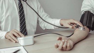 Man doctors use blood pressure monitors and stethoscope to measure pulse Diagnose the patient's disease in a modern hospital medical laboratory, Medical treatment and health check.
