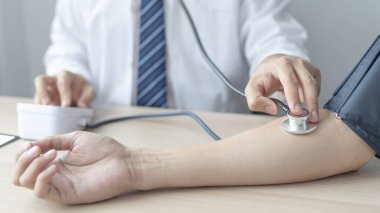 Man doctors use blood pressure monitors and stethoscope to measure pulse Diagnose the patient's disease in a modern hospital medical laboratory, Medical treatment and health check.