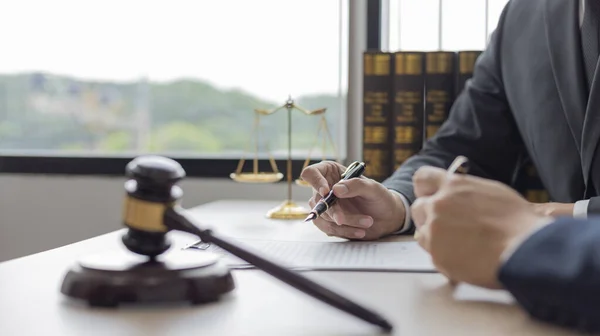 Lawyer or judge has recommend a client sign a legal agreement in the courtroom, Legal Agreement Documents and Business Litigation Forms, scales of justice, law hammer, Litigation and legal services.