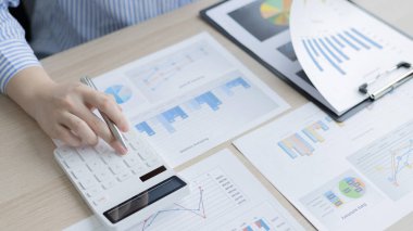 Genç Asyalı iş kadını, emlak yatırımcılarının gelir vergisi ve kurumsal gelirlerini hesaplamak için özel bir ofis, Finans, Muhasebe, Tex, İstatistiksel grafikleri ve emlak yatırımlarının hesap makinesine baskı yapıyor..