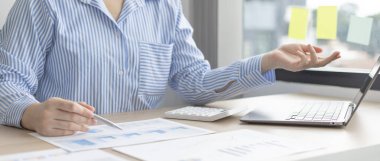 İş adamları şirketin yıllık gelir istatistiklerini, Gelir İstatistiklerini, Insight Graph, Finans, Muhasebe, Vergi Sistemi, Vat, Ofiste Çalışırken dizüstü bilgisayarları kullanarak verileri analiz ediyorlar.