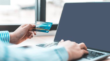 Kadının parmağı bir klavyeye basıyor ve ödeme veya çevrimiçi işlemler, mali işlemler ve İnternet güvenliği, İnternet üzerinden alışveriş ve bankacılık konseptini kaydetmek için kredi kartı tutuyor.