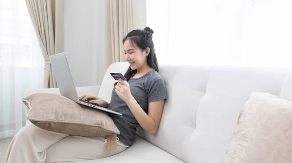 Asiatin Sitzt Auf Sofa Und Nutzt Laptop Online Mit Kreditkarte — Stockfoto