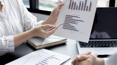 Brainstorm team, Marketers and financial accountants are discussing and analyzing charts to plan strategies to meet customer needs, Business data graph, Team meetings or business consulting.