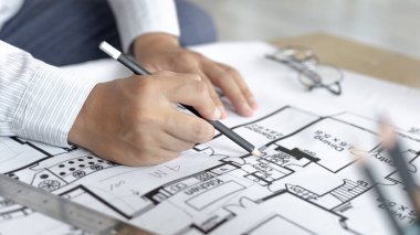 Mimari bina tasarımı ve planlı inşaat planları, kalem cetveli, kalem mezuralı, mezuralı, mimar şapkalı ve diğer ekipmanlı bir bina ya da mimari tasarım yapıyordu..