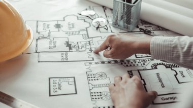 Mimari bina tasarımı ve planlı inşaat planları, kalem cetveli, kalem mezuralı, mezuralı, mimar şapkalı ve diğer ekipmanlı bir bina ya da mimari tasarım yapıyordu..