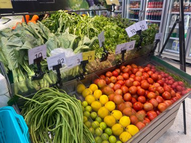 Tesco lotus, THAILAND- 25 Ağustos 2021: Çeşitli taze meyve ve sebzelerin rafları veya sepetleri tertipli, taze sebze veya meyve, organik gıda, Taylandlı insanlarla büyük süpermarket.