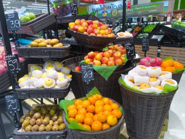 Tesco lotus, THAILAND- 25 Ağustos 2021: Çeşitli taze meyve ve sebzelerin rafları veya sepetleri tertipli, taze sebze veya meyve, organik gıda, Taylandlı insanlarla büyük süpermarket.