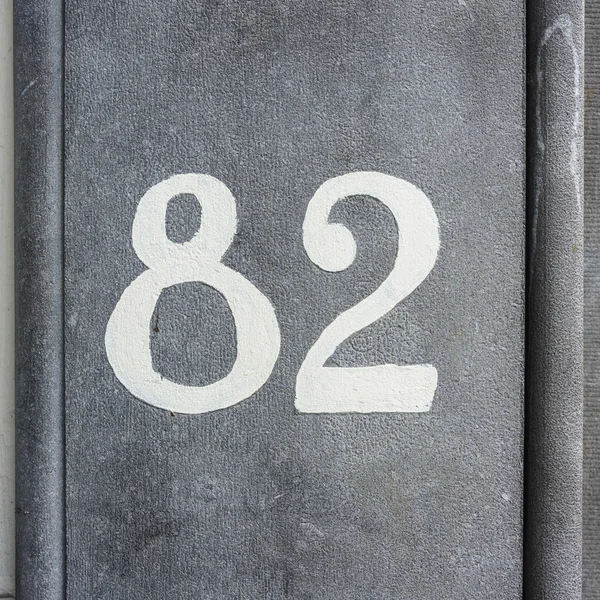 Číslo 82 - číslo domu Dvaaosmdesát, namalované na kamenné zdi — Stock fotografie