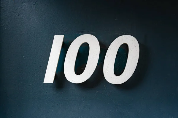 房子编号100 100 贴在粘贴墙上的分开字体 — 图库照片