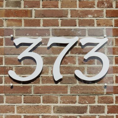 Üç yüz yetmiş üç numaralı ev şeffaf cam bir levhada..