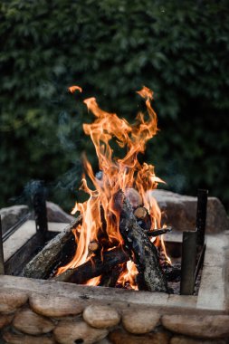 Yazlık evlerindeki ızgarada odundan yakılan şenlik ateşi. Ateşten gelen parlak alev.