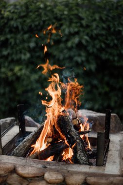 Yazlık evlerindeki ızgarada odundan yakılan şenlik ateşi. Ateşten gelen parlak alev.