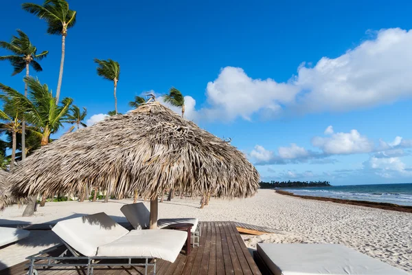 Liege am Strand, mit tropischem Meer als Hintergrund unter dem Sonnenschirm — Stockfoto