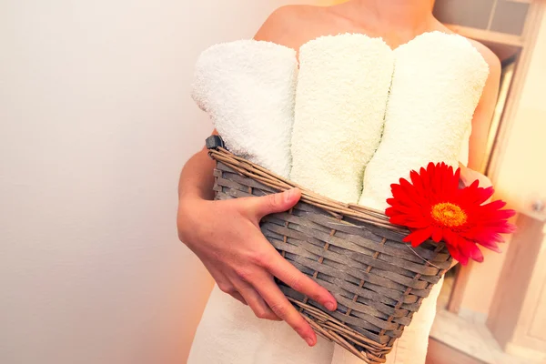 Flicka håller i handdukar och blomma, väntar massage Stockbild