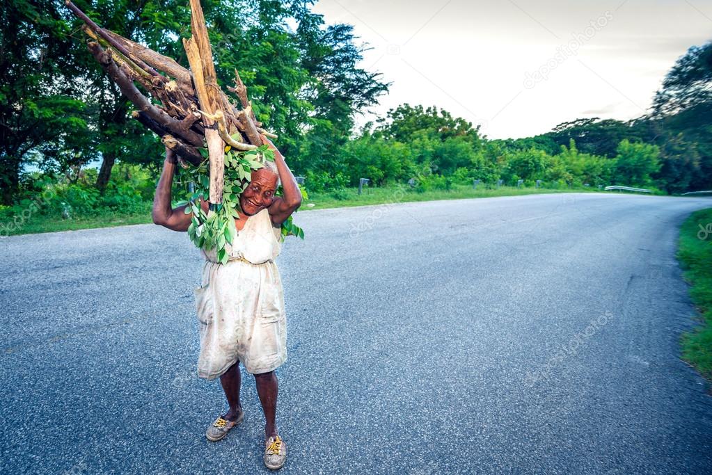 Frau, die Holzzweige auf einer Straße in der Nähe von Paraiso, Dominikanisc...