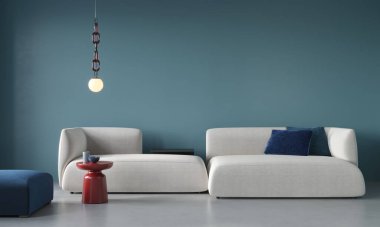 Büyük beyaz bir kanepe, bir puf, kırmızı bir masa ve mavi bir duvarın arka planında bir avize ve beton zemin olan şık bir oturma odası. 