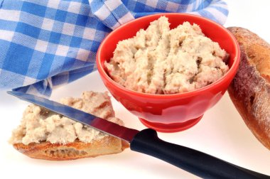 Beyaz arka planda bıçaklı ve ekmekli ramekin somon balığı. 