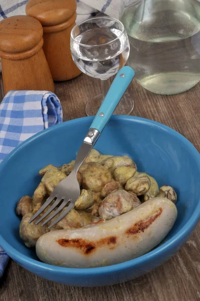 Plate of cooked white sausage with chestnuts close-up