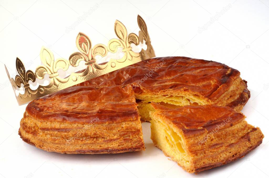 Galette des rois cut with a crown on white background 