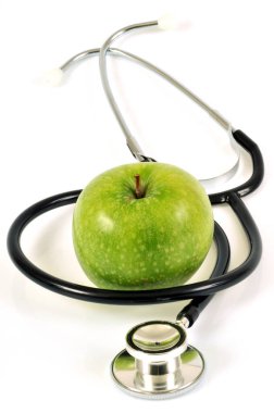 Beyaz arka planda steteskop ve büyükanne Smith elması. 
