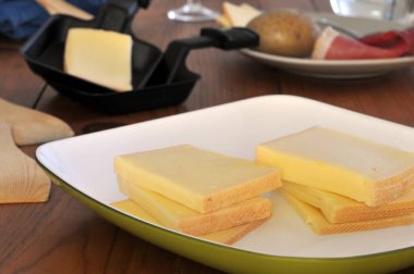 Bir tabak yakın planda raclette peyniri dilimleri.