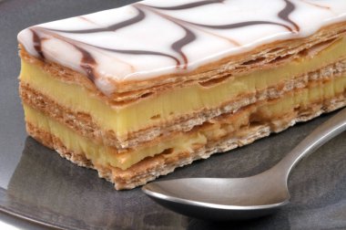 Millefeuille 'i bir kaşıkla yakın plan bir plakaya koy.