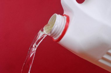 Kırmızı arkaplana çamaşır suyu dökülüyor 