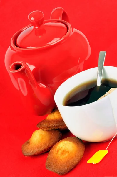 Madeleine Bir Fincan Çay Kırmızı Arka Planda Bir Çaydanlık — Stok fotoğraf