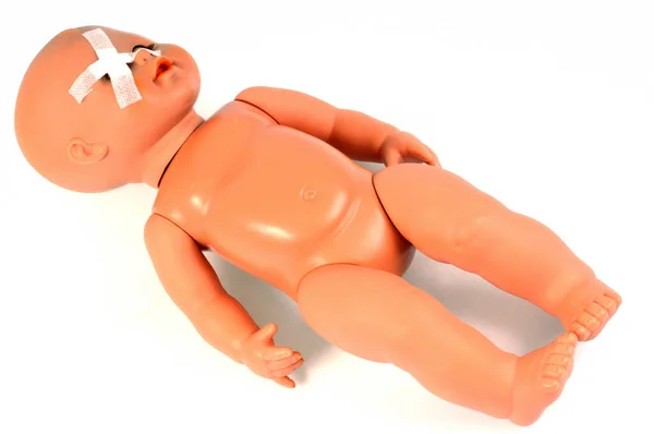 受了伤的儿童的概念与塑料娃娃有绷带的眼睛关闭在白色的背景 — 图库照片