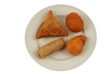 Beyaz arka planda çeşitli Asya yemekleri olan tabaklar