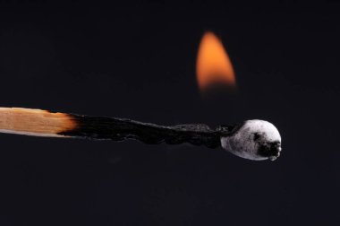 Siyah arkaplanda kibrit çöpü yaklaştırılıyor