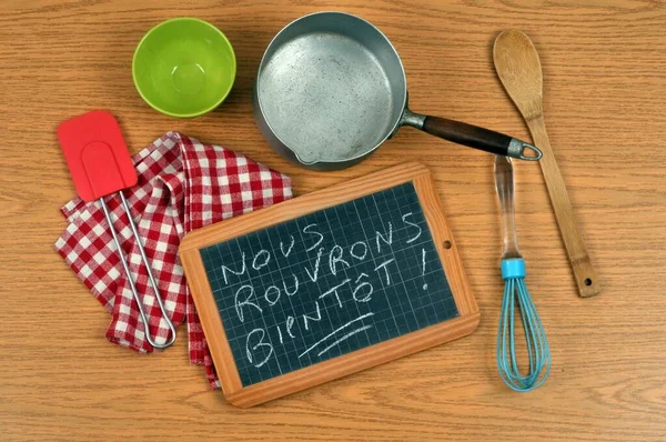 Concept of reopening restaurants with a school slate and kitchen utensils
