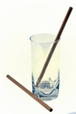 Bambu pipetleri beyaz arkaplanda yakın plan bir bardakta 