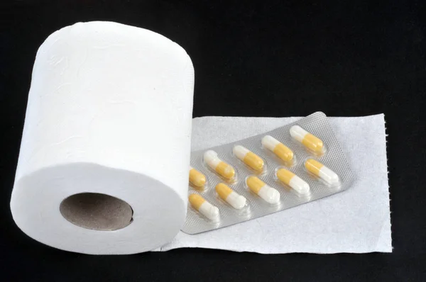 Constipation Concept Toilet Paper Roll Laxative Blister Pack Black Background — Stock Photo, Image