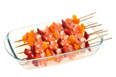 Beyaz arka planda karides ve biber şişleri yakın plan çekimde.