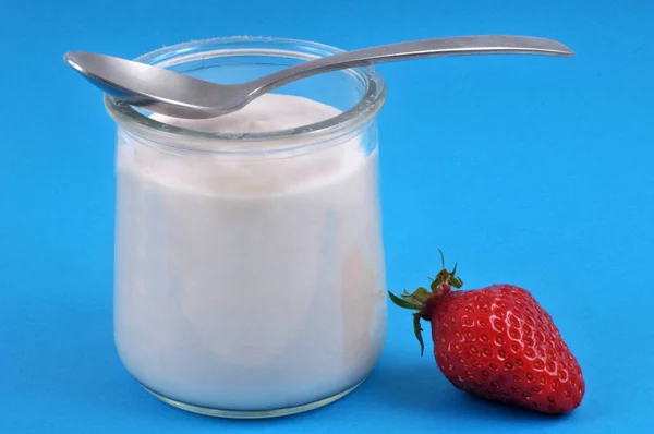 Erdbeerjoghurt Mit Einem Löffel Nahaufnahme Auf Blauem Hintergrund — Stockfoto