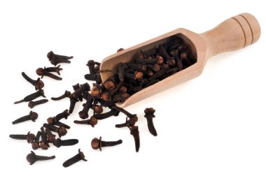 Tahta kaşıkla karanfiller beyaz arka planda yakın plan