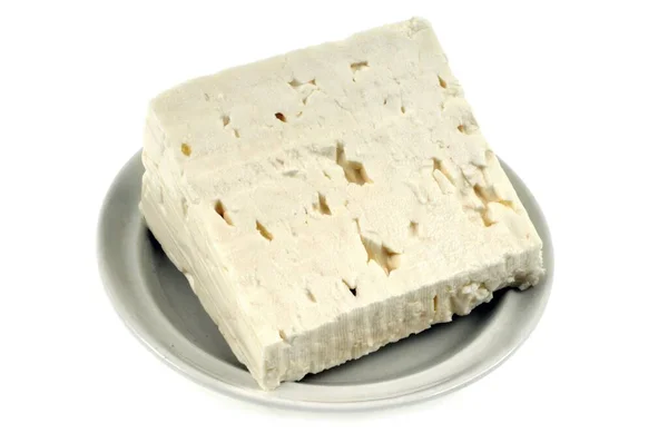 Beyaz Arkaplanda Bir Fincan Tabağı Içinde Bir Parça Peynir — Stok fotoğraf