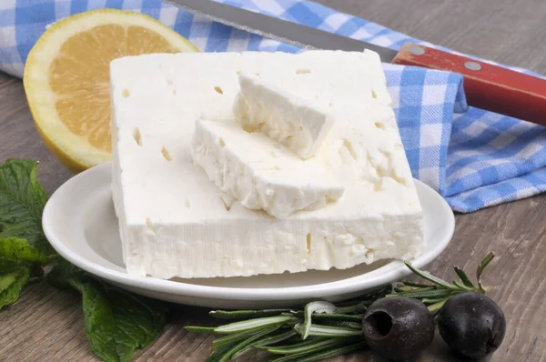 Feta Stück Einer Untertasse Mit Rosmarin Zitrone Schwarzen Oliven Und — Stockfoto