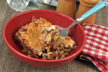 Çatal kapaklı bir tabakta servis edilen sığır eti lazanyası. 