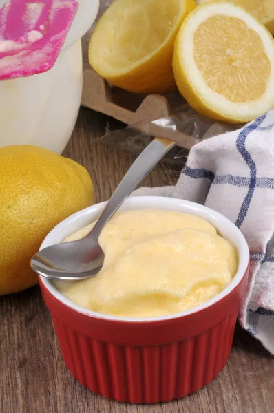 Ramekin of lemon cream with its ingredients and kitchen utensils