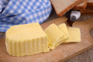 Bıçakla kesme tahtasına tuzlanmış tereyağı.