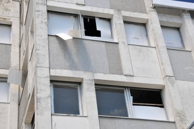 Kırık camları olan terk edilmiş bir binanın cephesi