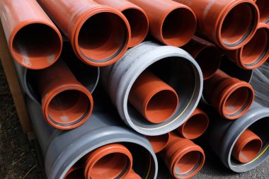 Farklı boyutlarda plastik borular üst üste yığılmış.