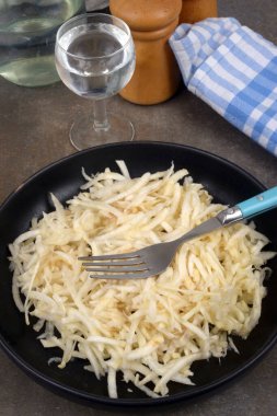 Bir bardak su ile servis edilen rendelenmiş kereviz tabağı.