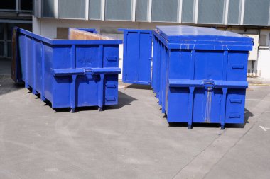 Container dumpster in the yard of a building