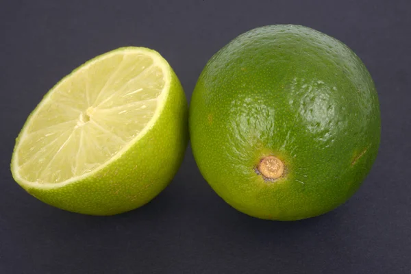 Limes Une Coupe Deux Gros Plan Sur Fond Noir — Photo