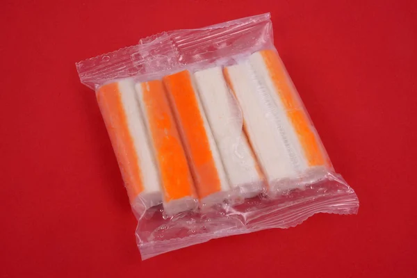 Surimi Rúd Műanyag Csomagolásban Közelkép Piros Háttér — Stock Fotó